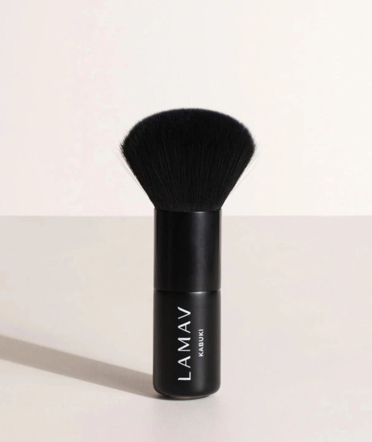 LAMAV Vegan Kabuki Brush standing upright. Black makeup brush with soft bristles for flawless powder blending.