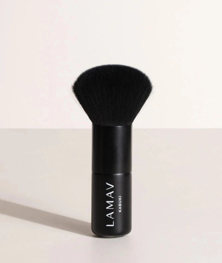 LAMAV Vegan Kabuki Brush standing upright. Black makeup brush with soft bristles for flawless powder blending.