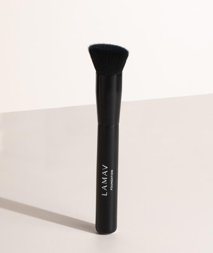 Standing LAMAV Vegan Foundation Brush casting a shadow. Dense, soft bristles for flawless makeup application.