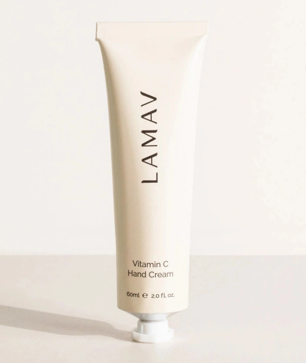 LAMAV Vitamin C Hand Cream 60ml tube standing upright on a minimalist surface. Brightening daily hand moisturizer.