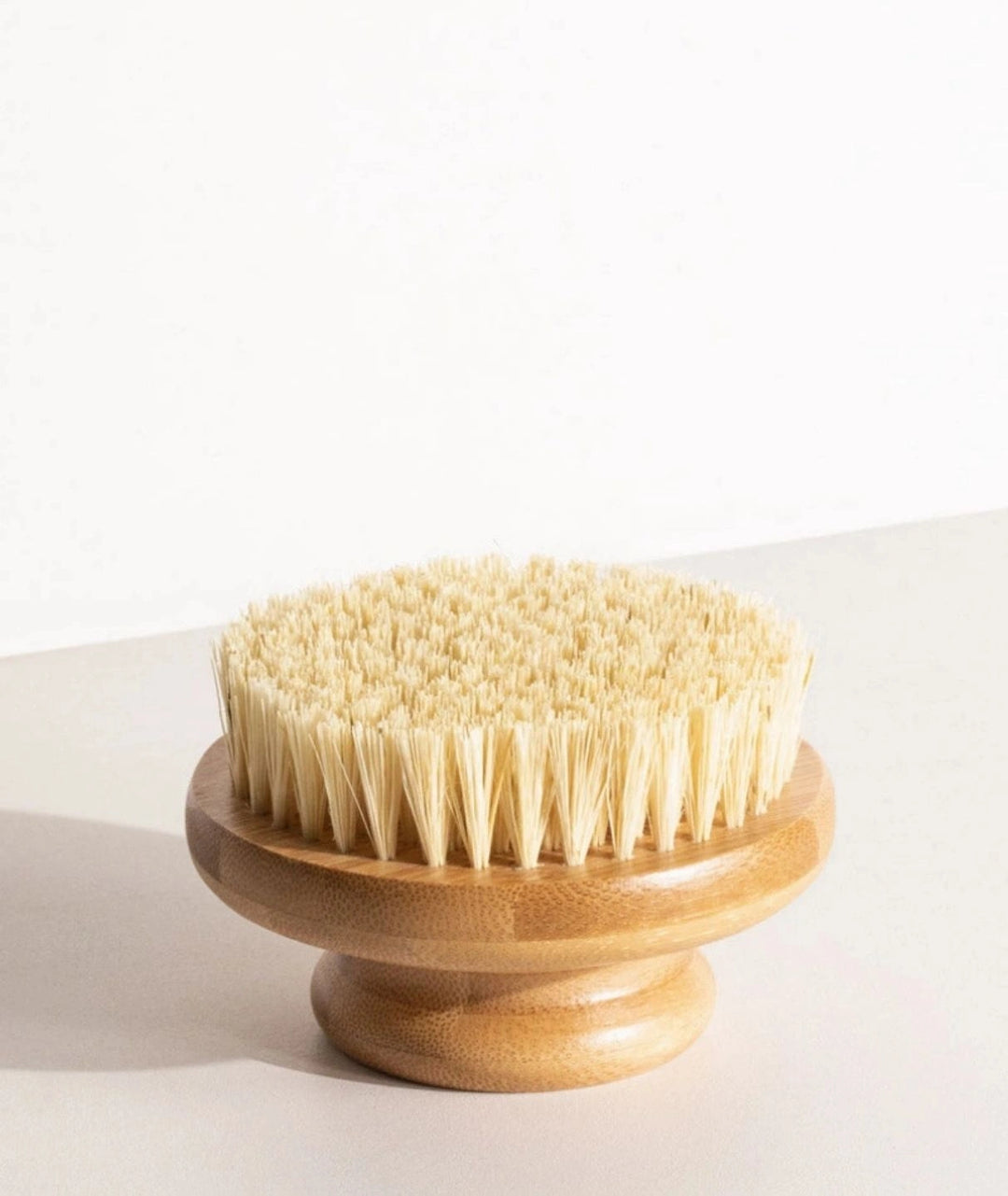 LAMAV wooden dry body brush sitting with its natural bristles facing upward.