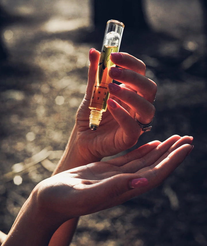 Serene Bodyhealth Lift essential oil perfume rollerball held over hand for application.