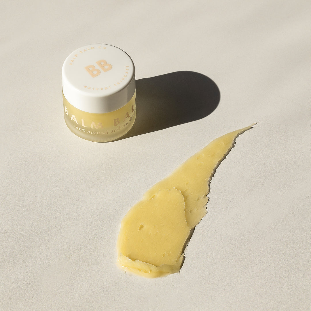 Balm Balm Co. natural lip butter container with creamy product smear, showcased in bright sunlight, ideal for organic skincare marketing in Australia.