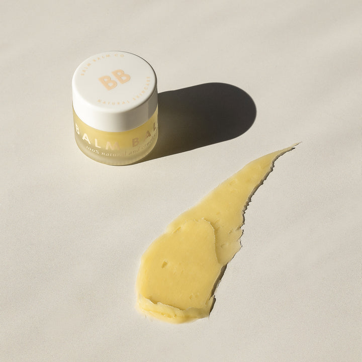 Balm Balm Co. natural lip butter container with creamy product smear, showcased in bright sunlight, ideal for organic skincare marketing in Australia.