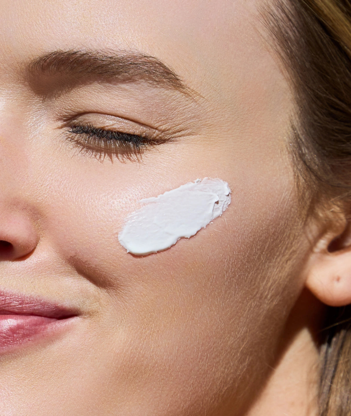 Applying Outside Beauty SPF 50+ Face Crème for broad spectrum daily facial sun protection.