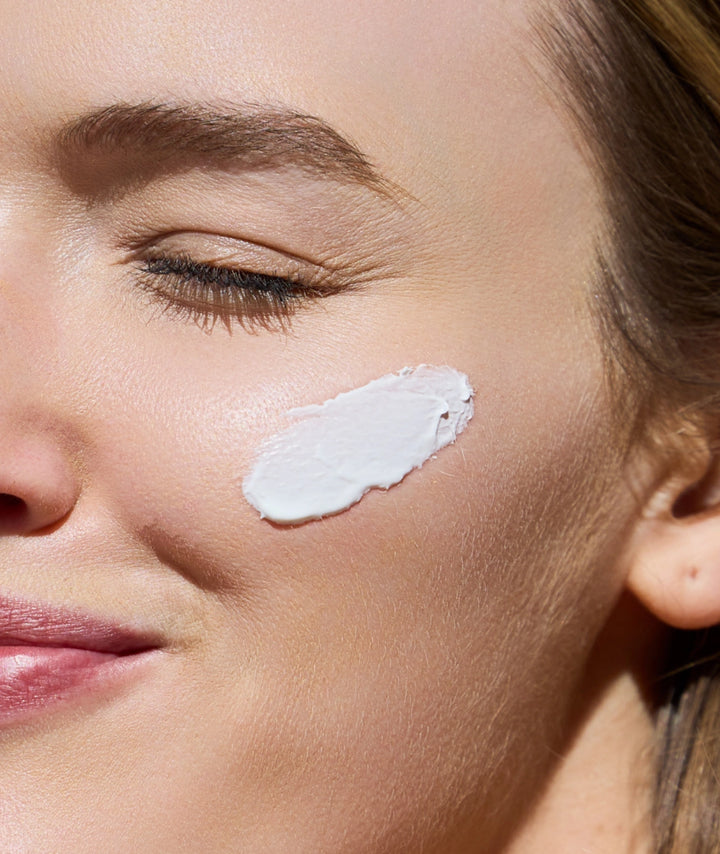Applying Outside Beauty SPF 50+ Face Crème for broad spectrum daily facial sun protection.