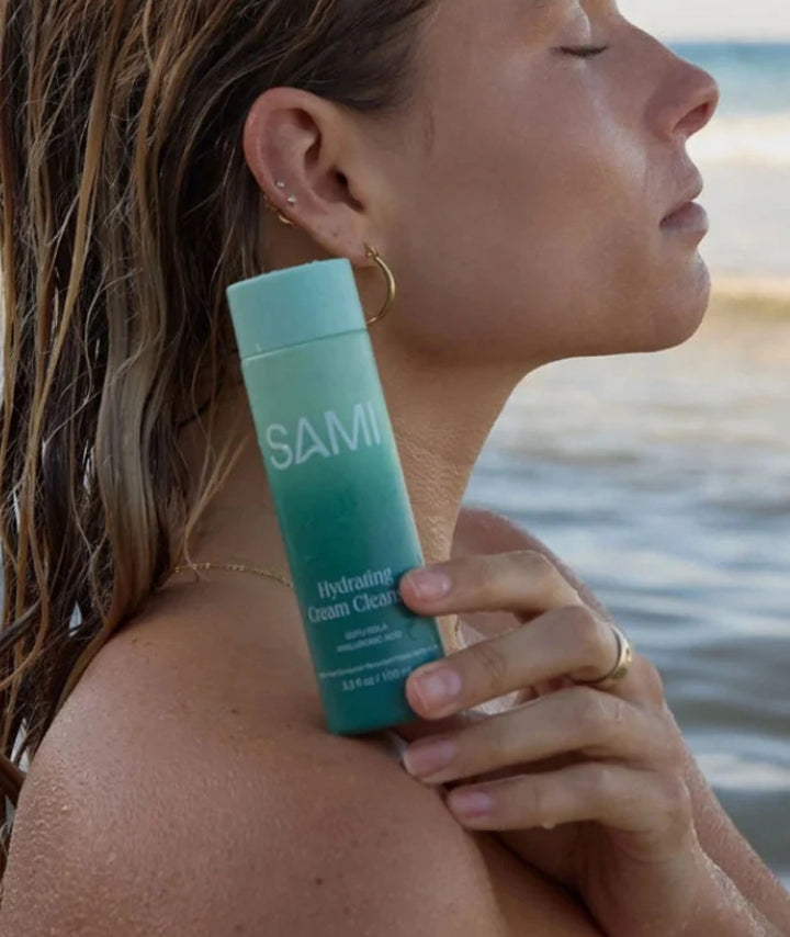 Hydrating Cream Cleanser by SAMI — model holding bottle by ocean | soothing cleanser for dewy skin