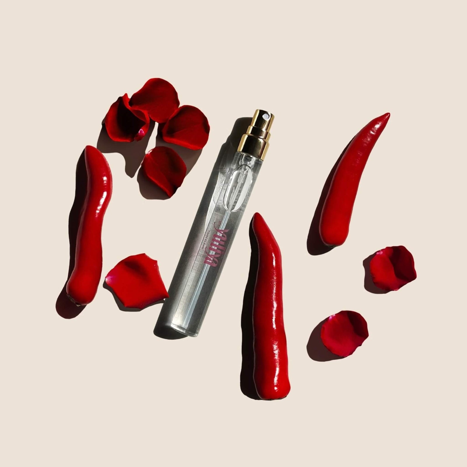 Phthalate free perfume mist by Yuliya Fragrances Australia. On a beige background surrounded by rose petals.