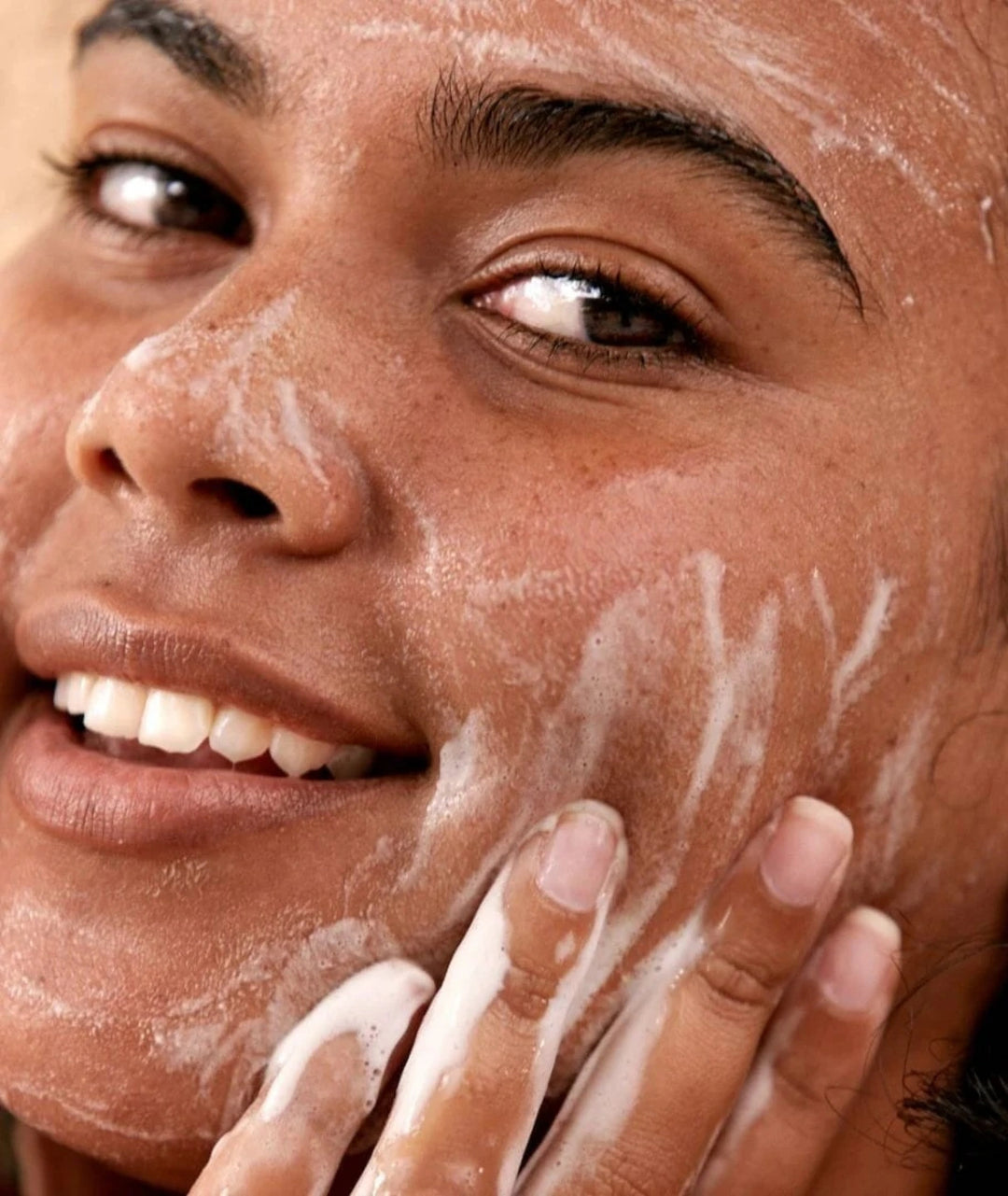 Model cleansing skin with Saya Cleansing Gel, a botanical face wash with marshmallow and chamomile.