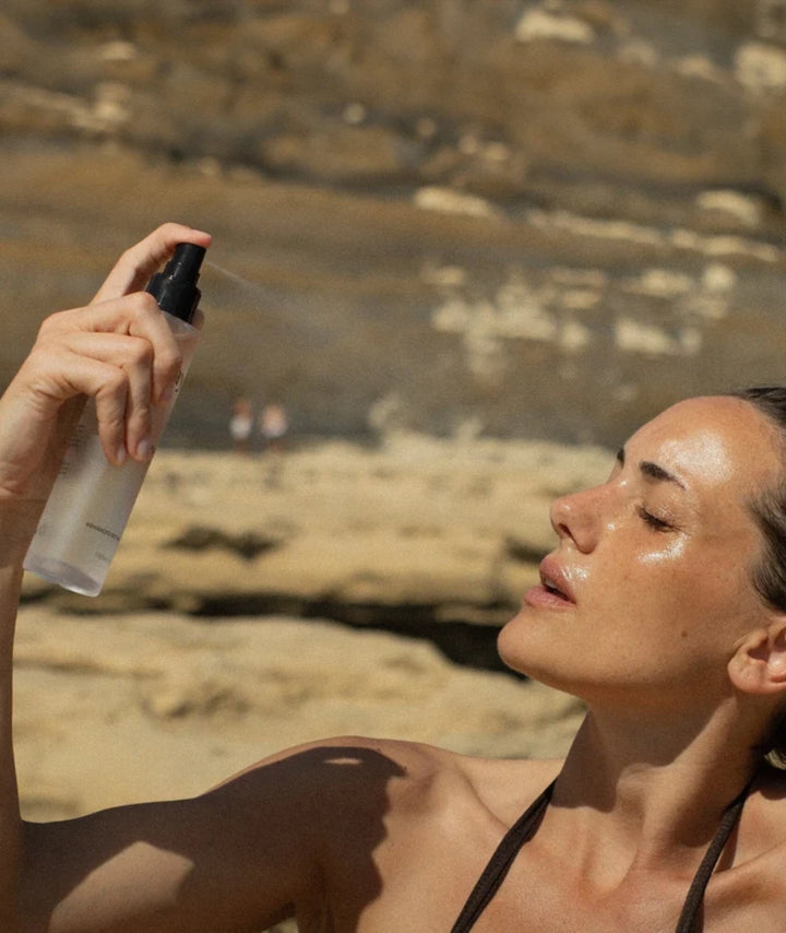 Model applying Saya Rose Hydrating Mist for instant hydration and refreshed, glowing skin outdoors.