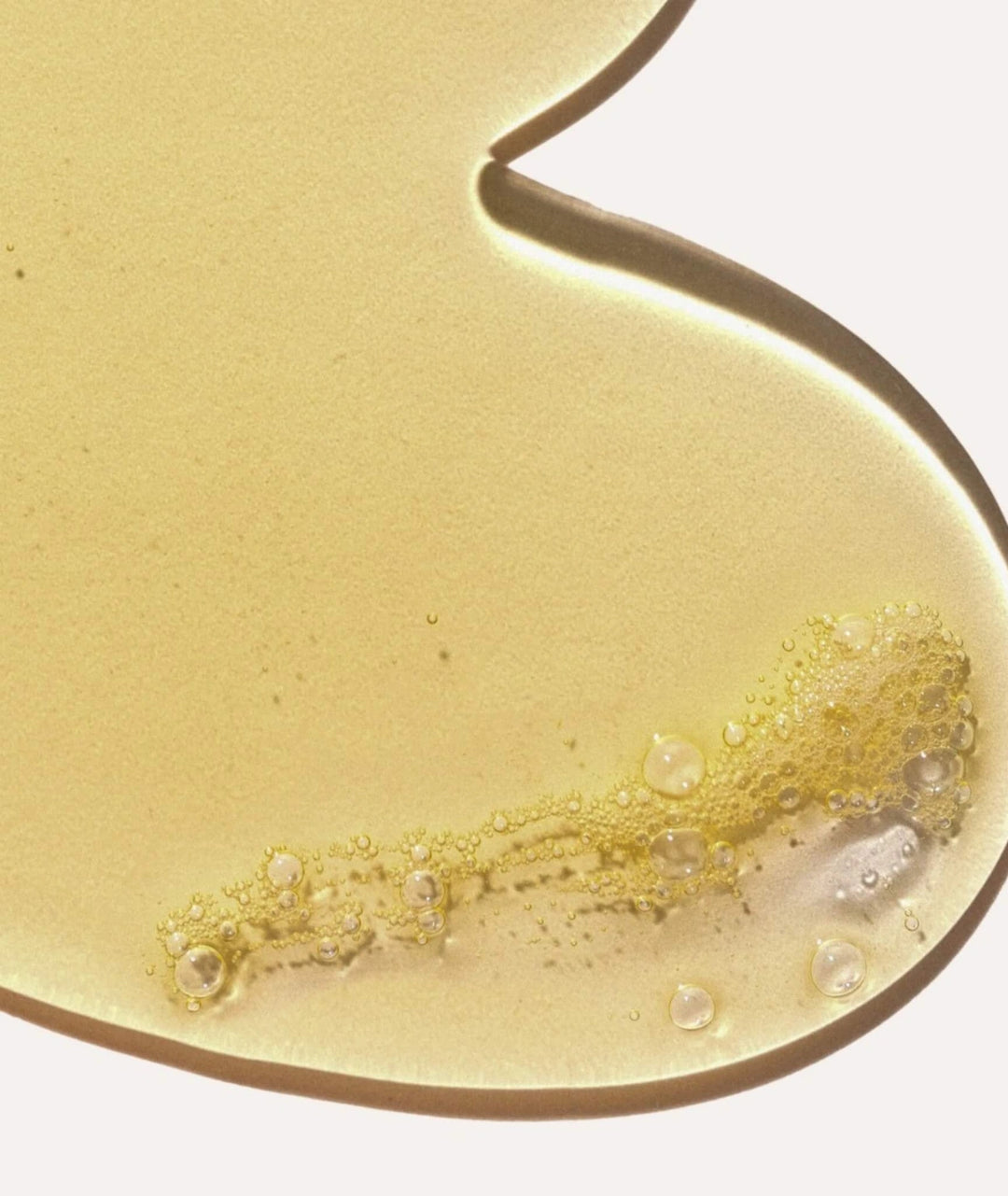 Macro close-up of golden Saya Body Wash gel texture featuring hydrating bubbles.