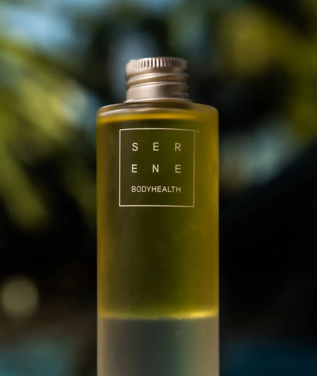 Serene Bodyhealth Deep Serene magnesium body oil bottle lit by natural outdoor sunlight.