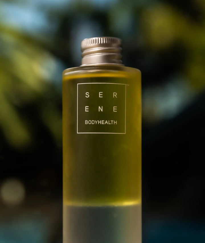 Serene Bodyhealth Deep Serene magnesium body oil bottle lit by natural outdoor sunlight.