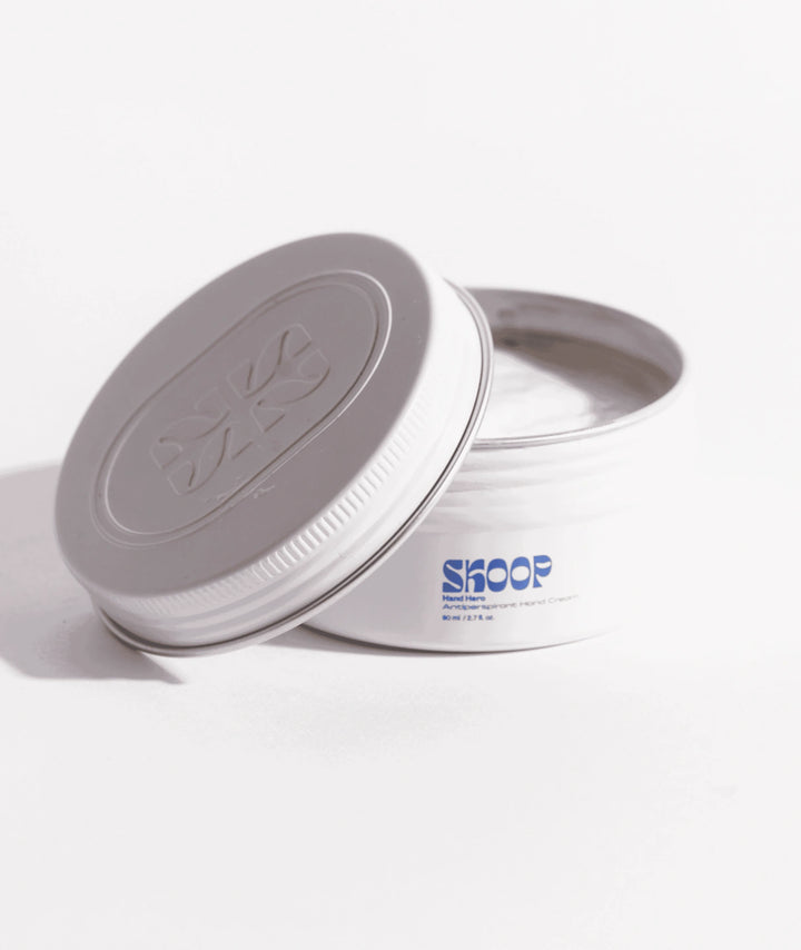 Open tin of Skoop Hand Hero Antiperspirant Dry Touch Hand Cream showing lightweight cream formula, designed to reduce hand perspiration, absorb moisture and maintain comfortable, dry hands.