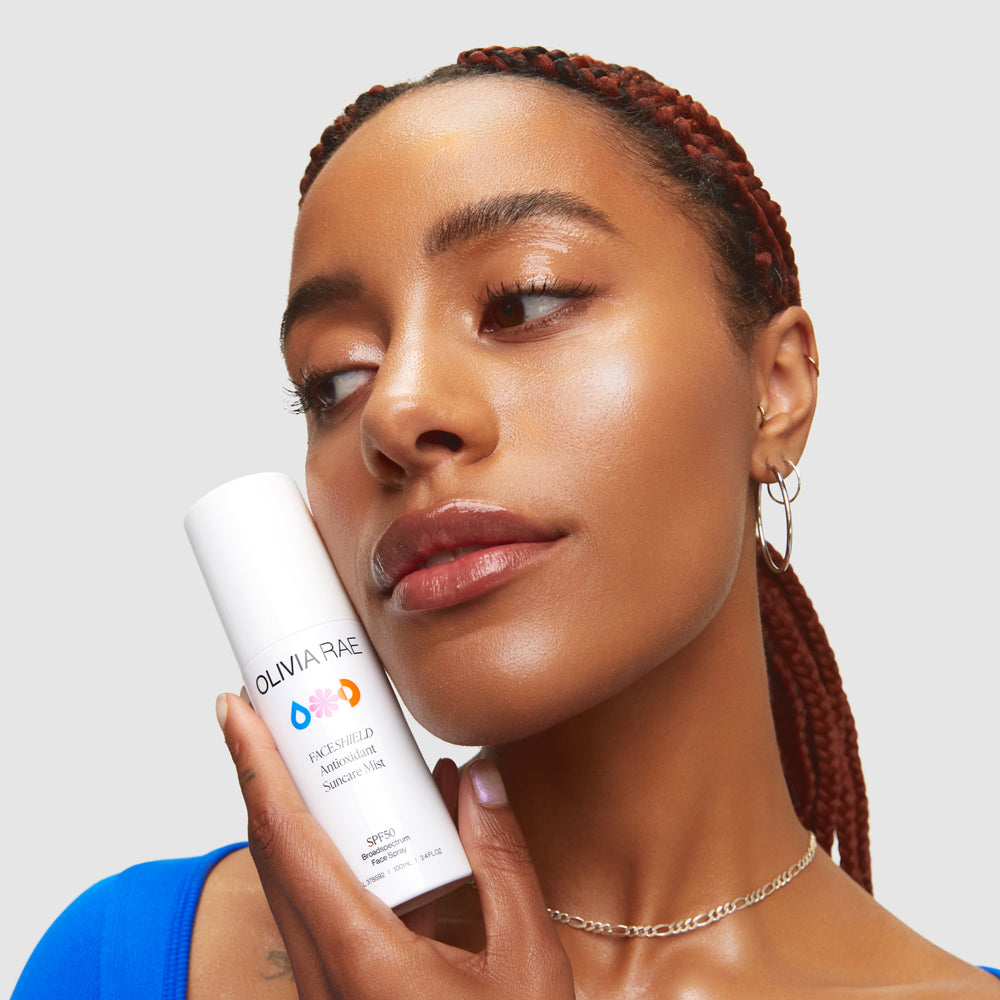 Australian-made Olivia Rae FACESHIELD Antioxidant Sunscreen Mist SPF50, held by a woman showcasing its easy application, available at VAMS BEAUTY SHOP – your go-to for luxurious, high SPF protection.