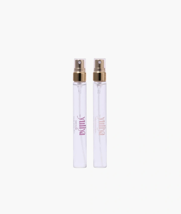 Two clear spray bottles of  travel size perfume set Australia with gold nozzles on a white background.
