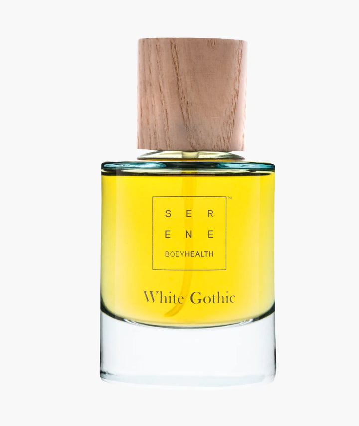 White Gothic fragrance by Serene Bodyhealth — clear glass bottle with golden liquid and a wooden cap.